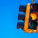 A yellow traffic light with a sky blue background